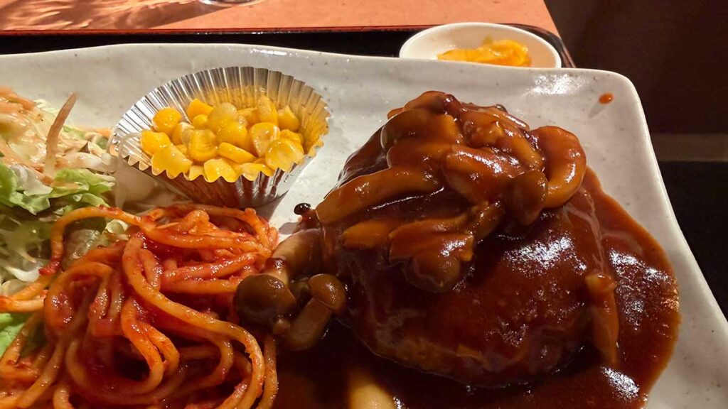 肉厚なハンバーグにかかったデミグラスソースのアップ